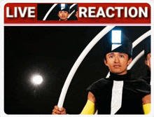 a man in a black and white outfit stands in front of a live reaction banner