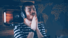 a man wearing headphones is praying with his hands folded