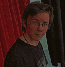 a young man wearing glasses and a black shirt that says ' i love you '