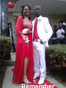 a man in a white suit and a woman in a red dress pose for a photo with the words remember below them