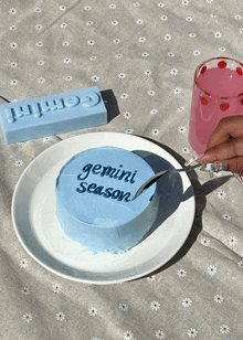 a small blue cake with the words gemini season on it