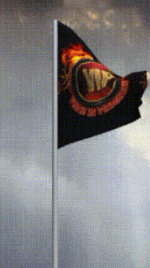 a black flag with a red and yellow circle with the letter v on it is flying in the wind