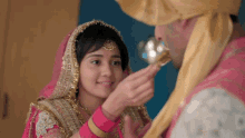 a bride and groom are looking at each other and the groom is feeding the bride a piece of cake