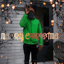 a man in a green jacket is standing in front of a door with the words merry christmas written above him