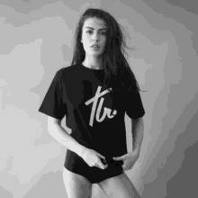 a black and white photo of a woman wearing a black t-shirt that says " tv "