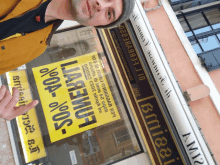 a man stands in front of a store front with a yellow sign that says 0%