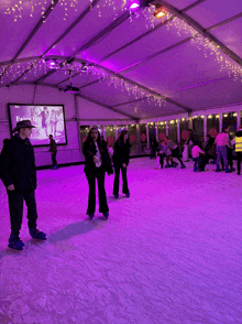 a group of people are ice skating in front of a large screen that says fairy tale on it