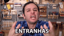 a man in a plaid shirt is making a funny face with the word entranhas written on the screen behind him