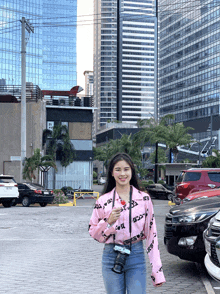 a woman wearing a pink shirt that says ' gucci ' on it stands in a parking lot