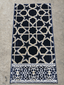 a black and gold rug with a pattern on it