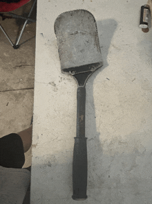 a spatula with a black handle sits on a table