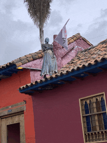 a statue of a woman on top of a building with a flag that says ' a ' on it