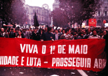 a group of people holding a banner that says viva o 1o de maio