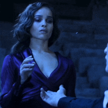 a woman in a purple dress is being held by a man in a black suit