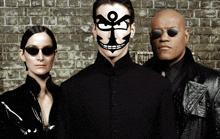 a man with an ankh on his face is standing next to a woman and a man with sunglasses