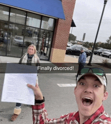 a man holding up a piece of paper that says finally divorced