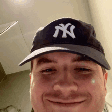 a man wearing a new york yankees hat is smiling