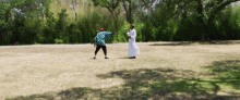 a man in a kimono and a man in a white robe are standing in a field with trees in the background