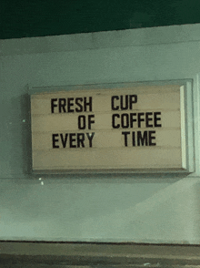 a sign on the side of a building says fresh cup of coffee every time