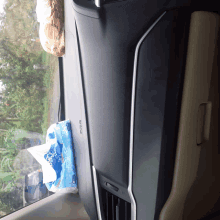 a bag of tissues sits on a car dashboard