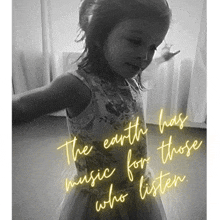 a little girl is standing in front of a sign that says the earth has music for those who listen