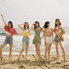 a group of women standing on a beach with one wearing a crop top that says ' hawaii ' on it