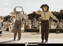 a man with a tv head is dancing with a man with a lion head