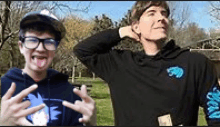 two young men are standing next to each other in a park making funny faces .