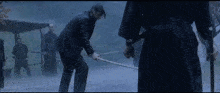 a man is holding a sword in a foggy area