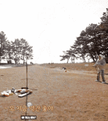 a person is standing in a field with trees in the background and a sign that says ' korean ' on it