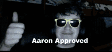 a man wearing sunglasses giving a thumbs up and the words aaron approved below him