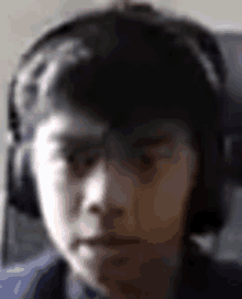 a close up of a person wearing headphones looking at the camera .