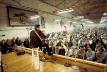 a man playing a guitar in front of a large crowd