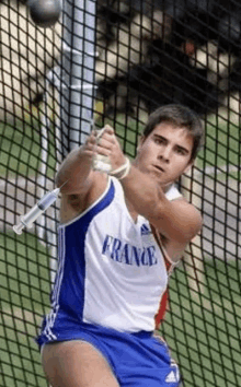 a man wearing a france jersey is throwing a shotgun