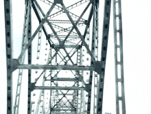 looking up at the steel structure of a bridge with a white background