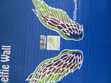 a blue wall with wings painted on it and a sign that says selfless wall