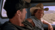 two men in cowboy hats are sitting in a car