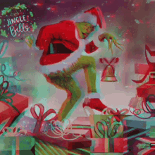 the grinch is wearing a santa hat and holding a bell while standing on a pile of gifts .