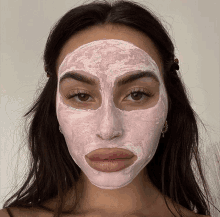 a woman is wearing a pink face mask on her face