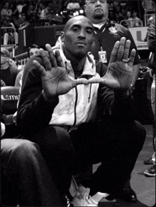 a man sitting in a stadium with his hands in the air