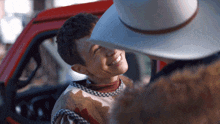 a man in a cowboy hat talks to a boy in a plaid sweater