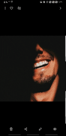 a man with a beard is smiling in the dark with his mouth open