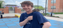 a young man in a thrasher shirt holds a squirrel