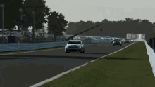 a silver car is driving on a race track