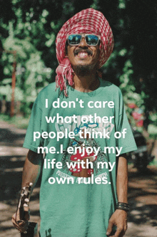 a man wearing sunglasses and a green shirt with a quote on it