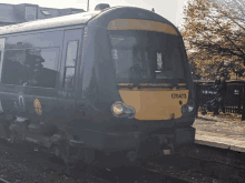 a black and yellow train with the number 170473 on the front