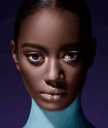 a close up of a woman 's face with a blue turtleneck