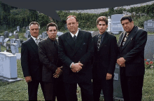 a group of men are standing in front of a cemetery with a tombstone that says ive on it