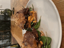 a white plate topped with meat and vegetables on a table