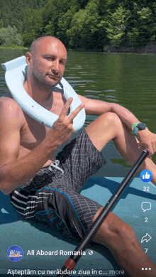 a man in a life preserver is sitting on a raft in the water with a facebook post from all aboard romania